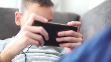 男孩智能手机坐着沙发首页男孩玩移动游戏在线首页